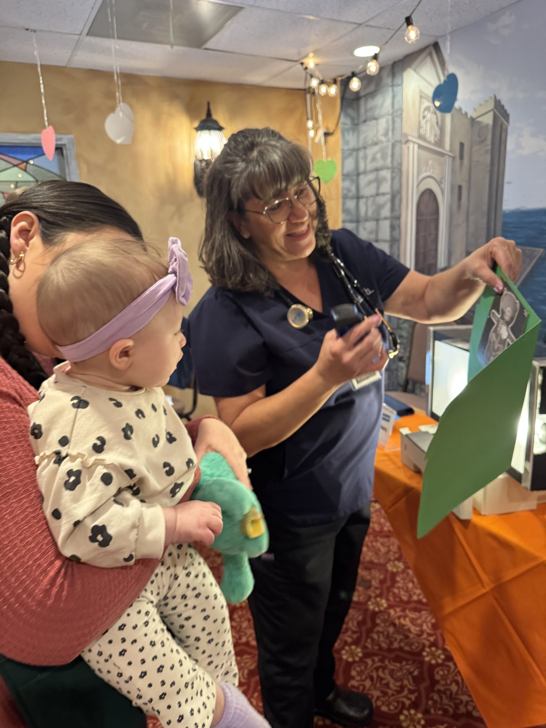 Nurse showing baby a picture during checkup