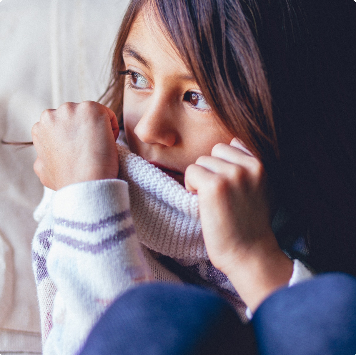 Child looking outside wearing cozy sweater