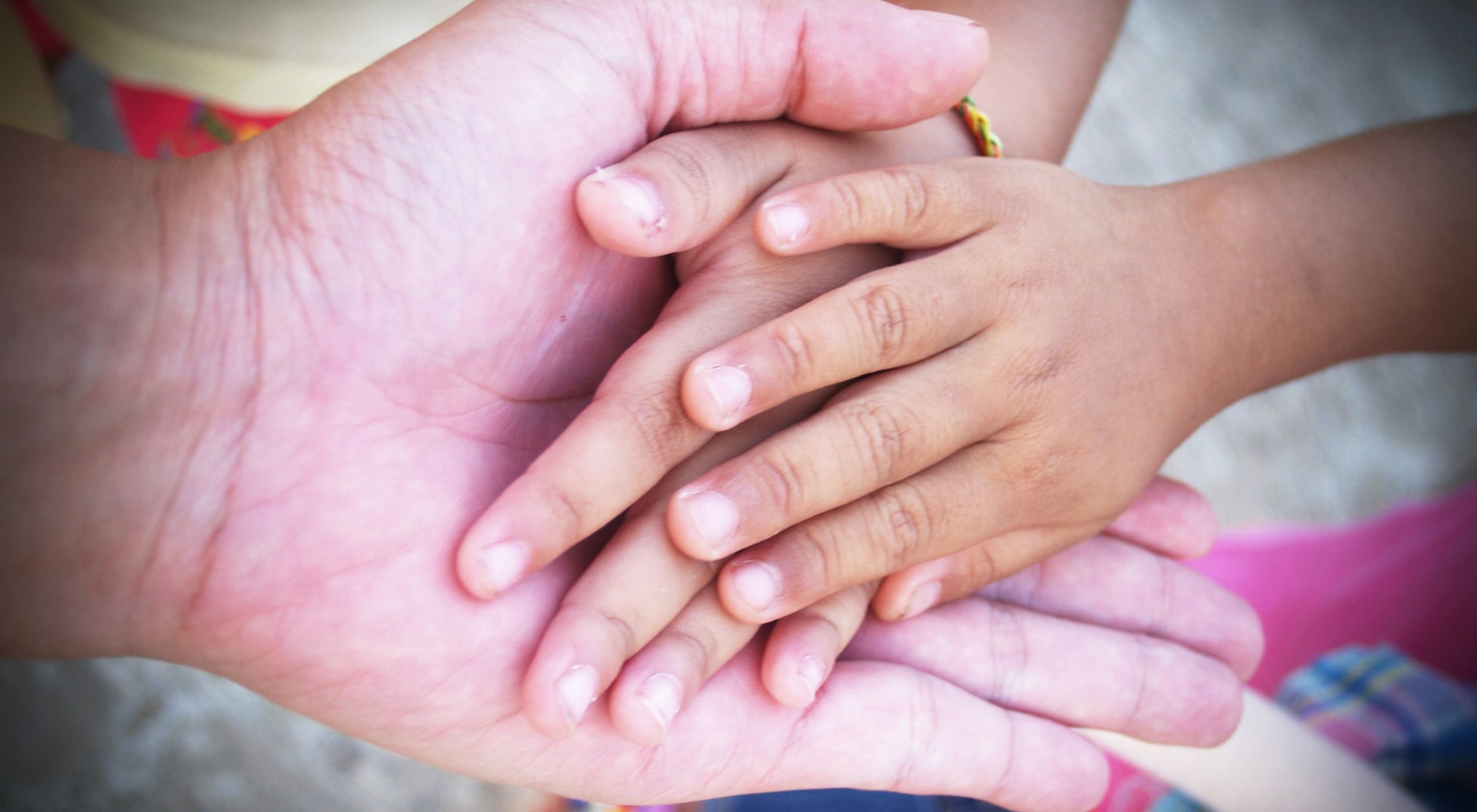 Adult and child hands touching gently