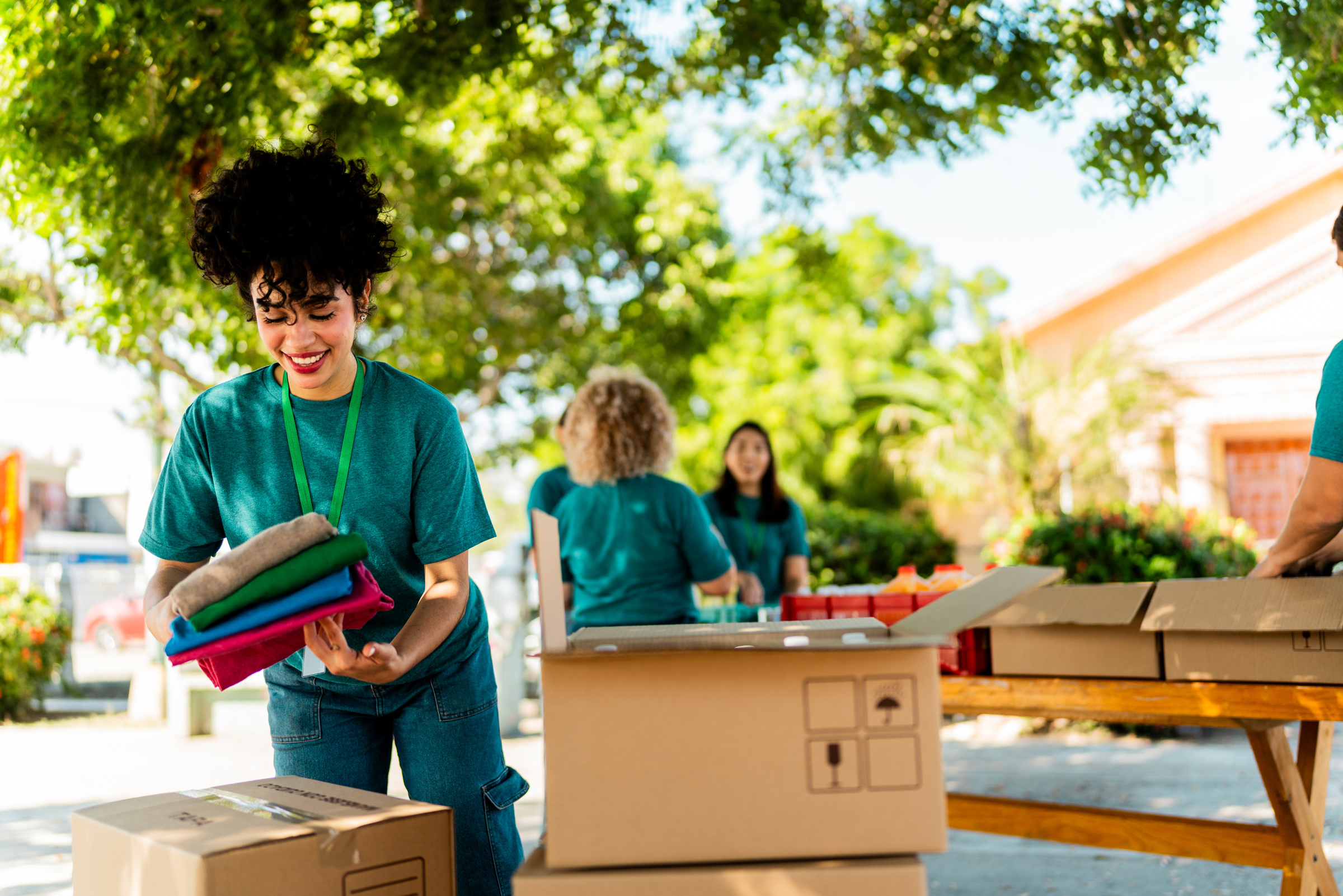 Volunteers packing clothes into donation boxes outdoors
