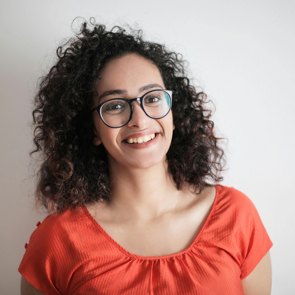 Smiling woman wearing glasses and orange shirt