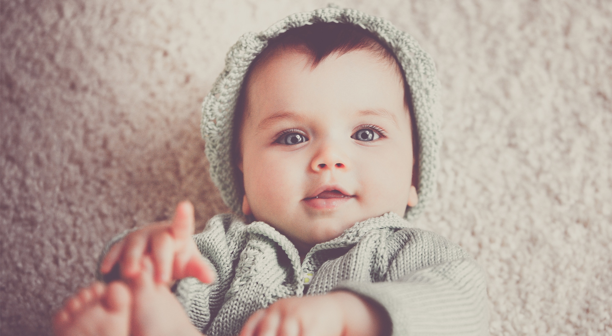 Smiling baby wearing knitted sweater and hat