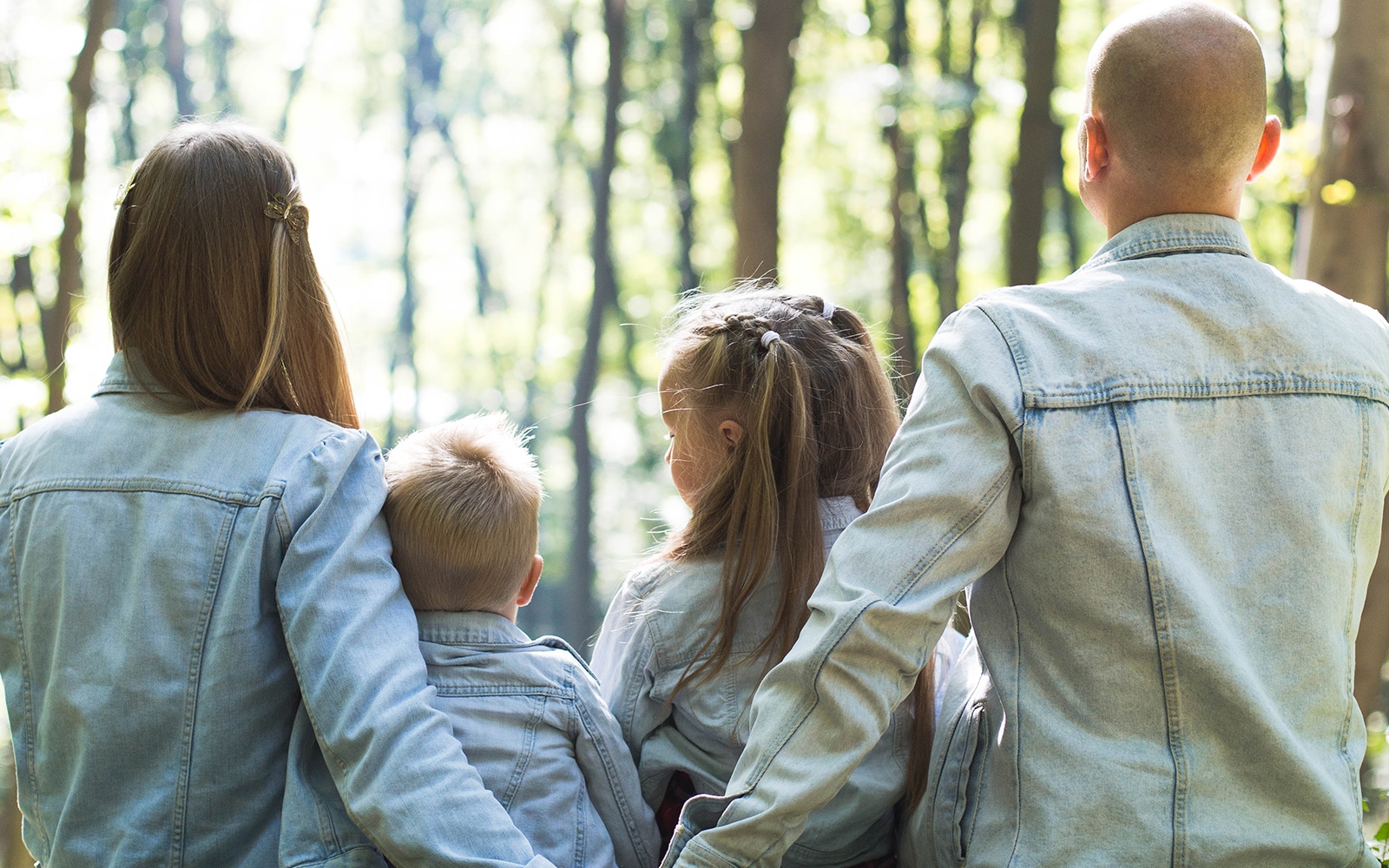 Family wearing denim jackets in forest